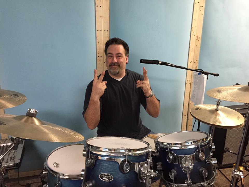 At the drum kit in a rehearsal room