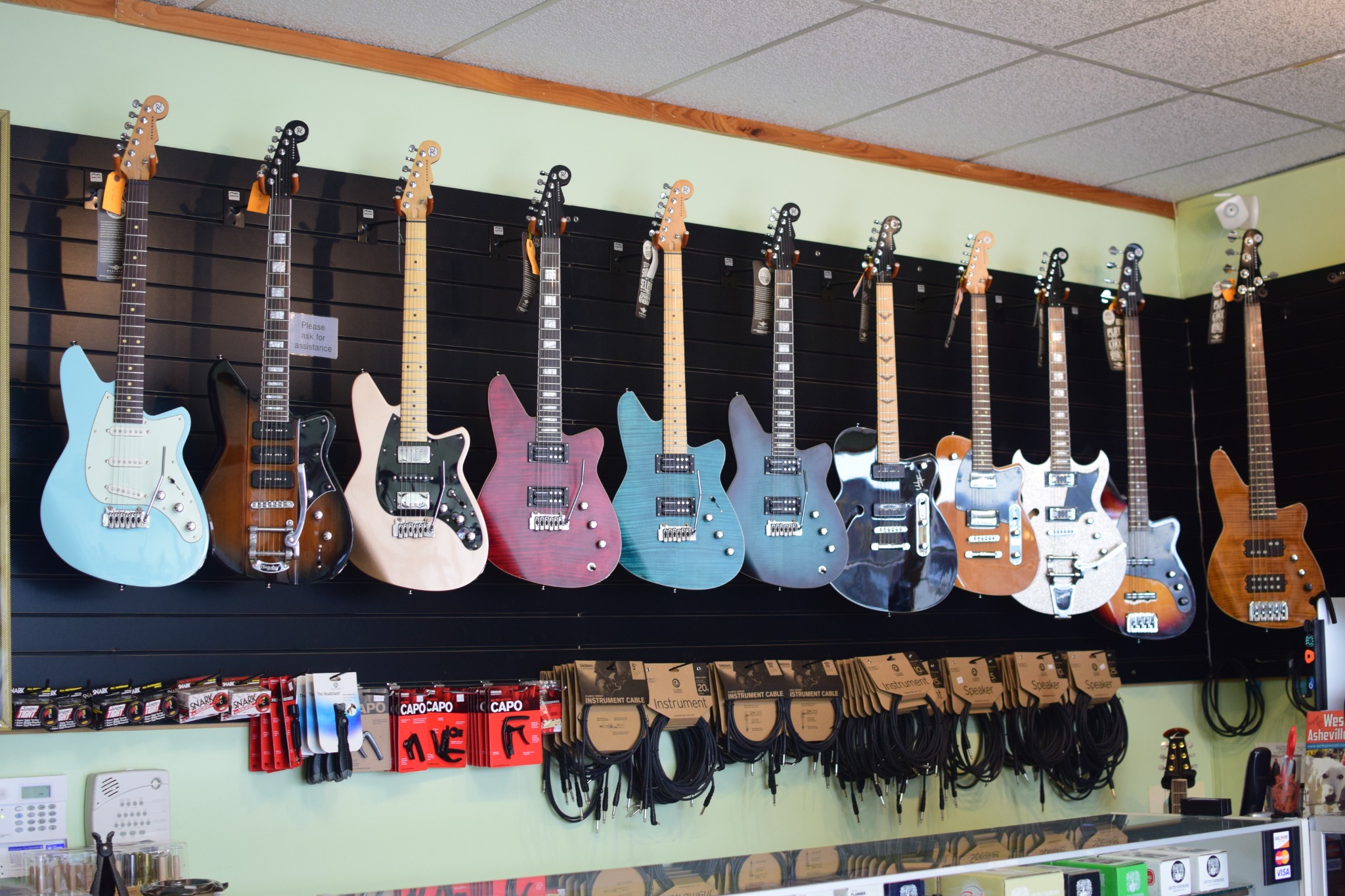 Colorful electric guitars displayed on the shop wall